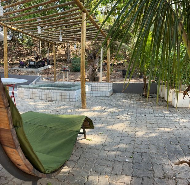 Varanda relaxante com redes, área de fogueira e jardim arborizado do NaNena